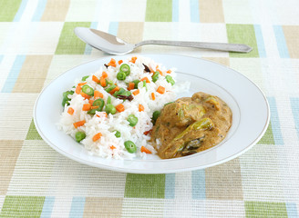 Indian food rice pilaf, which is a popular and traditional dish, and side dish curry made from long green pepper or chili.