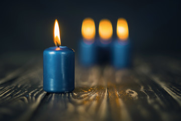 Lit four blue candles on wooden counter