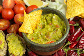 Guacamole in home crafted bowl with tortilla chips inside.