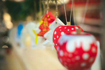 Christmas toys in the blurry bokeh. handmade ornaments hanging on threads, decorated with fir branches