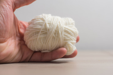Gomitolo di lana bianco in mano