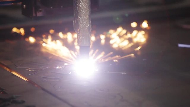 Laser cutting of flat sheet metal steel material with sparks.