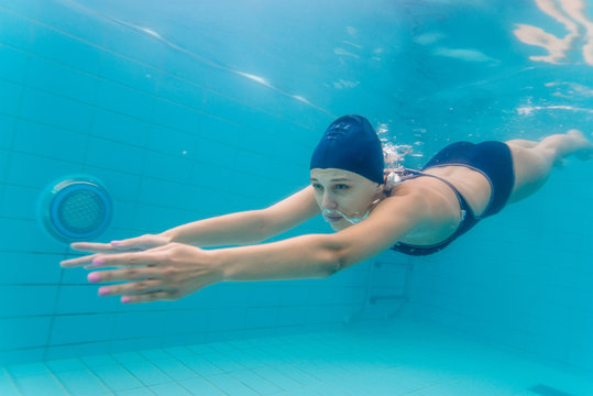 Woman swimming underwater in pool