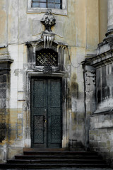 Fototapeta na wymiar Facade of the Dominican Cathedral, Lviv, Ukraine. Fragment with door and window metal grill.