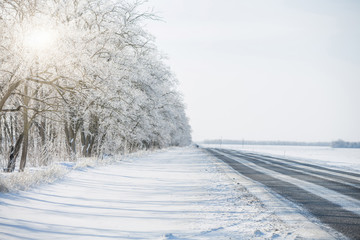 Obraz na płótnie Canvas Snowy road. Winter snowfall. Trees in the snow.