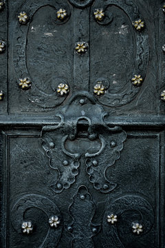 Vintage Black Door Decorated With Metal Flower. Close Up.