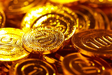 Golden coins piled in a heap of background