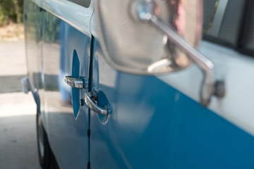 Close up of a vintage blue car and rear view mirror