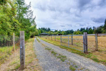 Fototapeta premium Open gate to a horse farm in the countryside