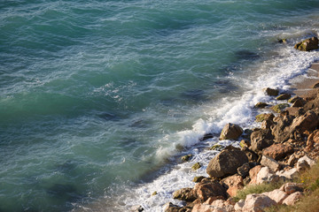 Wild beach with rocky shore and pure black sea