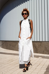 Young beautiful african girl walking down city. Fashion street style.