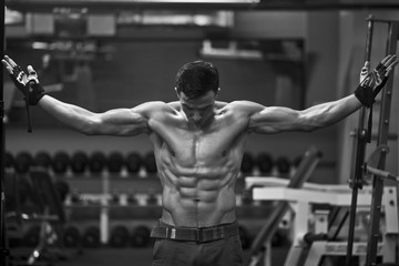 Athlete muscular brutal bodybuilder posing in the gym