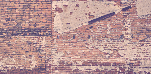 Old vintage red brick wall with fallen plaster for background.