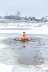 Winter swimming. Man in an ice-hole in outdoors