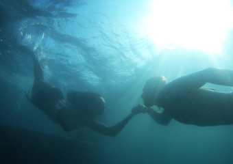 Fototapeta na wymiar love story.man and woman floats underwater