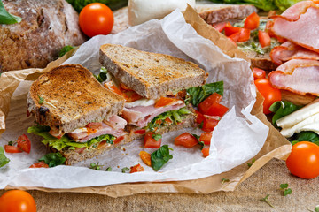Fresh BLT Sandwich with Bacon Lettuce Tomato and Mozzarella on crumpled paper
