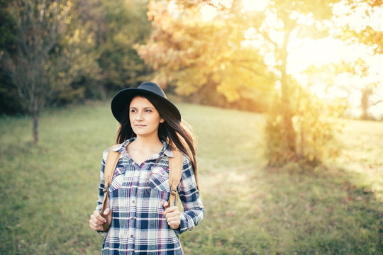 Portrait of pretty young woman with hat and backpack