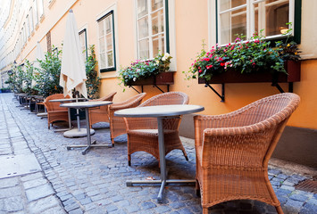 Fototapeta na wymiar Street view of a coffee terrace with tables and chairs in europe