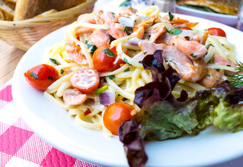 Fototapeta na wymiar close-up of plate of pasta and smoked salmon with tomato