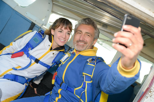Male and female skydivers taking selfie