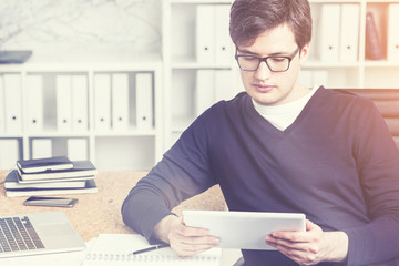 Young accountant using tablet at work, toned