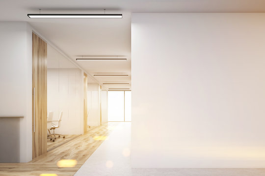 Office with blank wall and row of meeting rooms, toned
