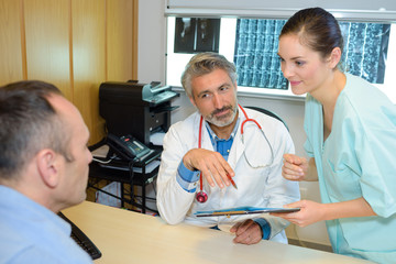 Doctor and nurse talking to male patient