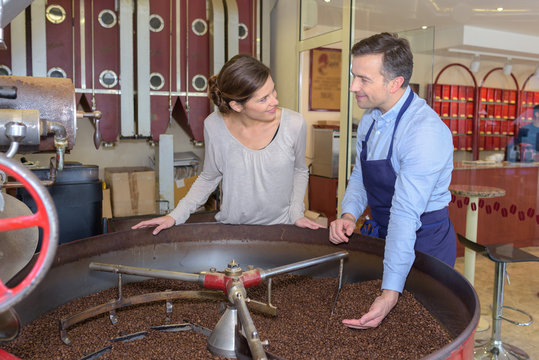 employees testing coffee quality during roasting at factory