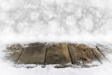 Alte Holzbretter im Schnee mit Bokehhintergrund