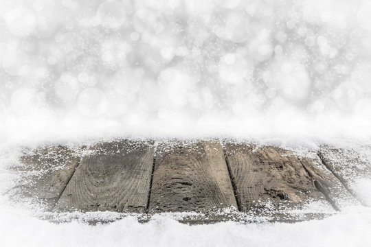 Alte Holzbretter im Schnee mit Bokehhintergrund