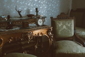 Details of vintage furniture with retro metal winding clock,  armchairs and wooden tables. - 125904113