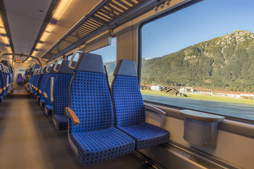 Obraz premium Krzesła i widok przez okno - Wygodne krzesła w nowoczesnym niemieckim pociągu, z pięknym widokiem na alpejskie okna