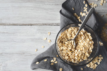 Oat flakes in a glass bowl on the wooden table