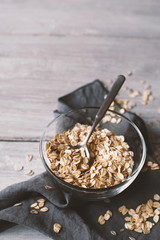 Oat flakes in a glass bowl on the wooden table