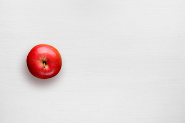 Red apple on white table top view