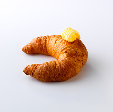 Croissant With Butter Curl On White Background