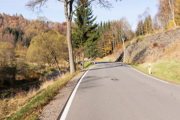 Narrow empty asphalt S-Curved road in autumn