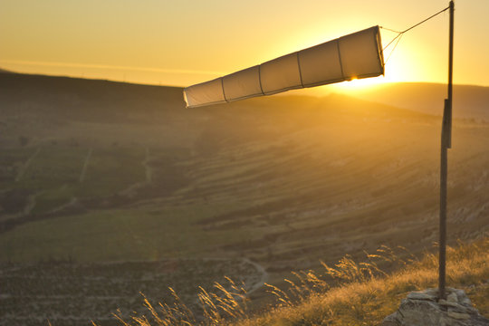 windsock at sunset in mountains against sun