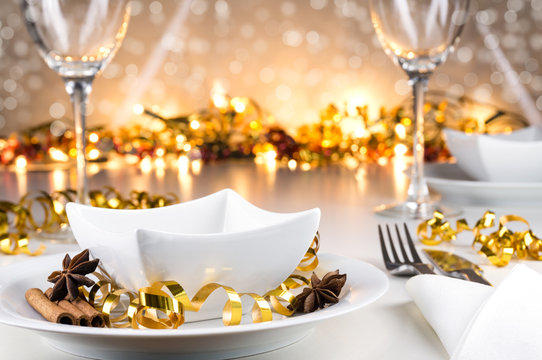 Weihnachtlich, festlich dekorierter Tisch mit Geschirr und Bokehhintergrund
