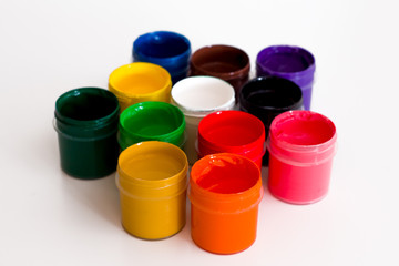 several colorful open jars of gouache