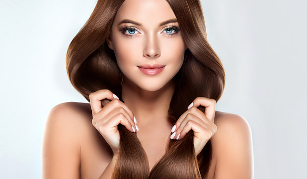 eautiful model girl with shiny brown straight long  hair . Care and hair products .

