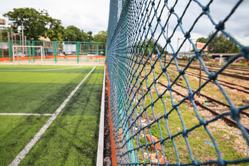 Goal net with green grass field