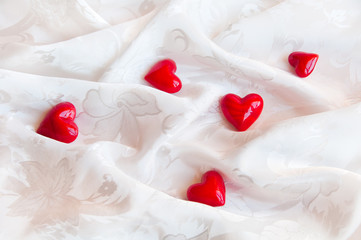 Obraz na płótnie Canvas Red hearts on white fabric