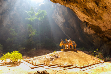 Obraz premium Morning sunbeam on golden buddhist pavilion in wild cave, Sam Roi Yot, Thailand