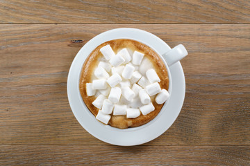 cup of cappuccino with marshmallow on table