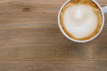 cup of freshly made cappuccino on wooden table