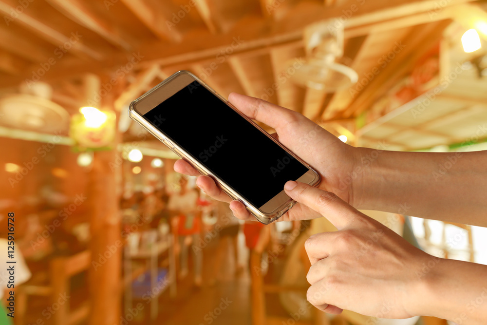 Wall mural Woman Hand holding smartphone with Geometry symbol in the restaurant for order some food