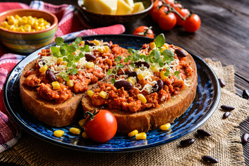 Fried toasts with chicken meat, tomato, chili, pepper, beans and