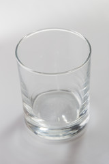 Empty colorless glass on white background