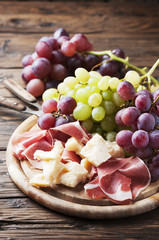 Fototapeta na wymiar Antipasto with grape, cheese and ham